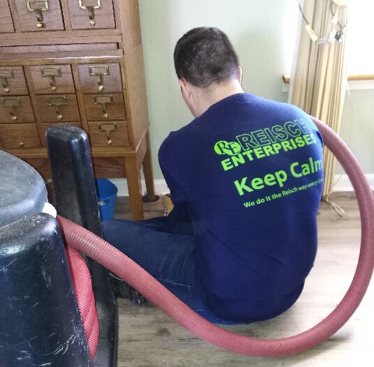 A Reisch Enterprises employee is professionally cleaning out an air duct.